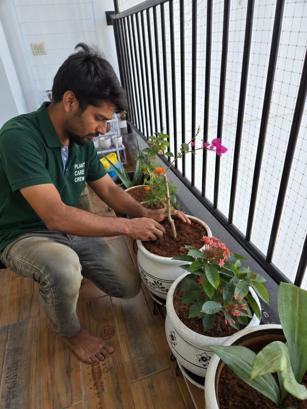 Plant Baddies gardener planting in a white pot on a balcony